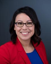 Smiling Vice Provost Klusmeier wearing a red jacket and blue top